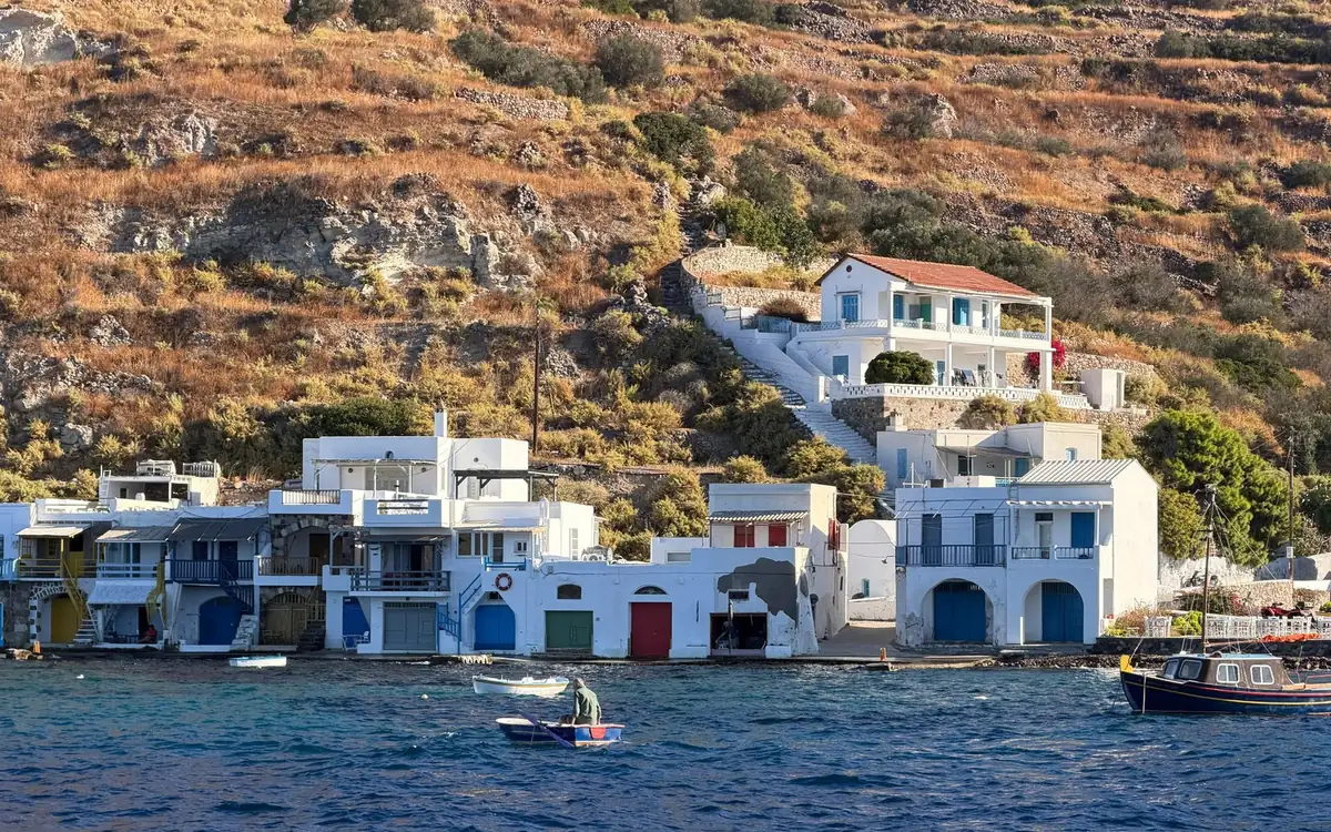 Casas brancas de pescadores com portas coloridas de casas de barcos à beira da água